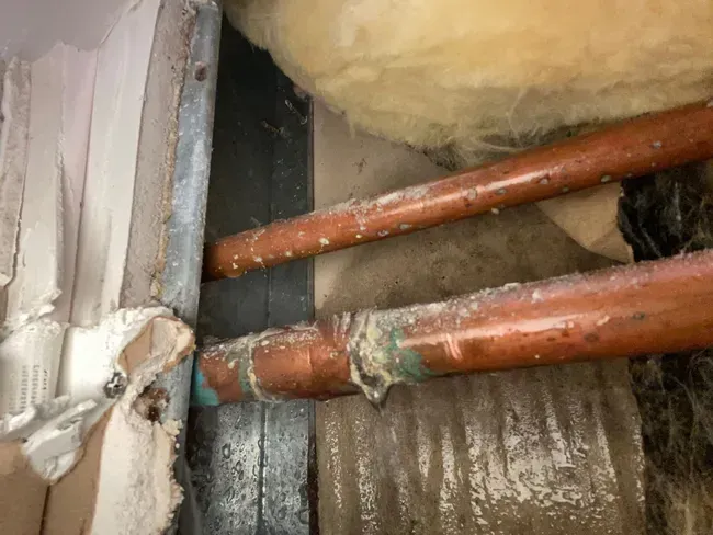 A close up of a copper pipe in a room.