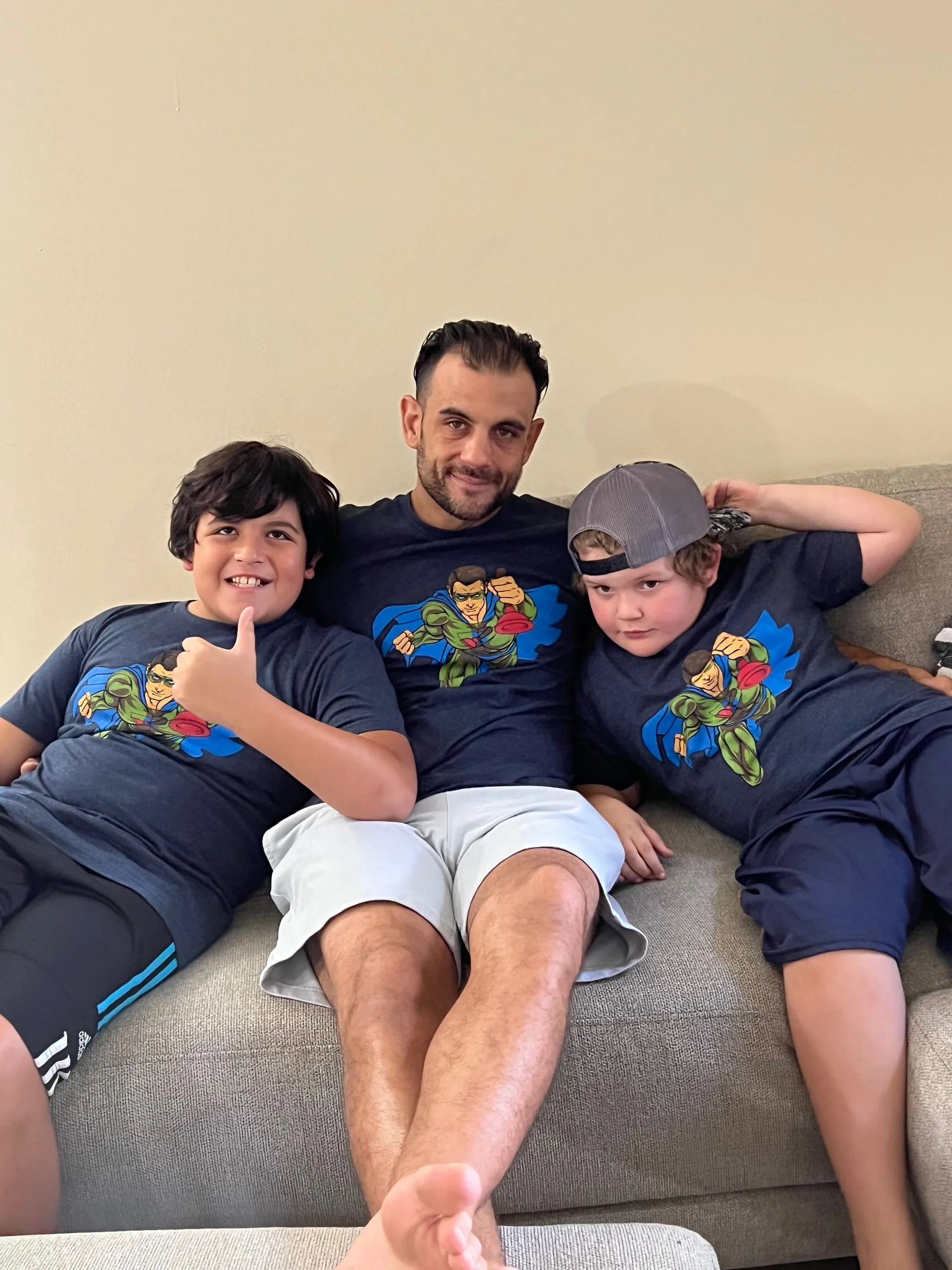 A man and two boys are sitting on a couch.